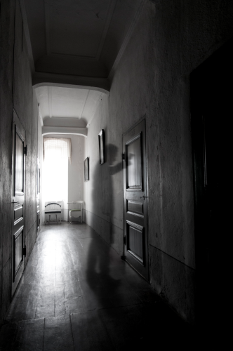 En genomskinlig figur står i korridoren utanför spökrum nummer 13 och knackar på dörren.