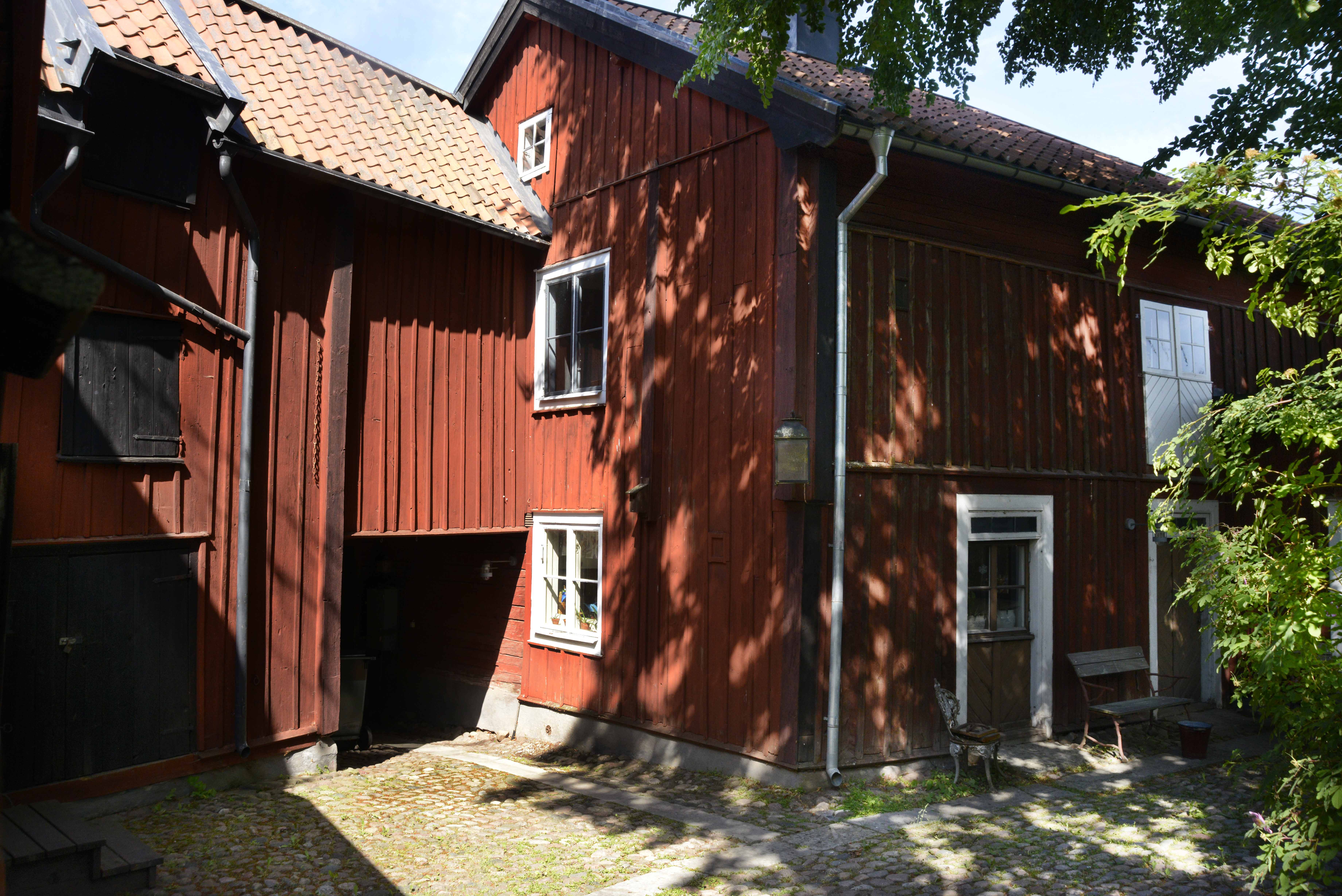 Onkel Adamsgården i Linköping, exteriör med röda träbyggnader.