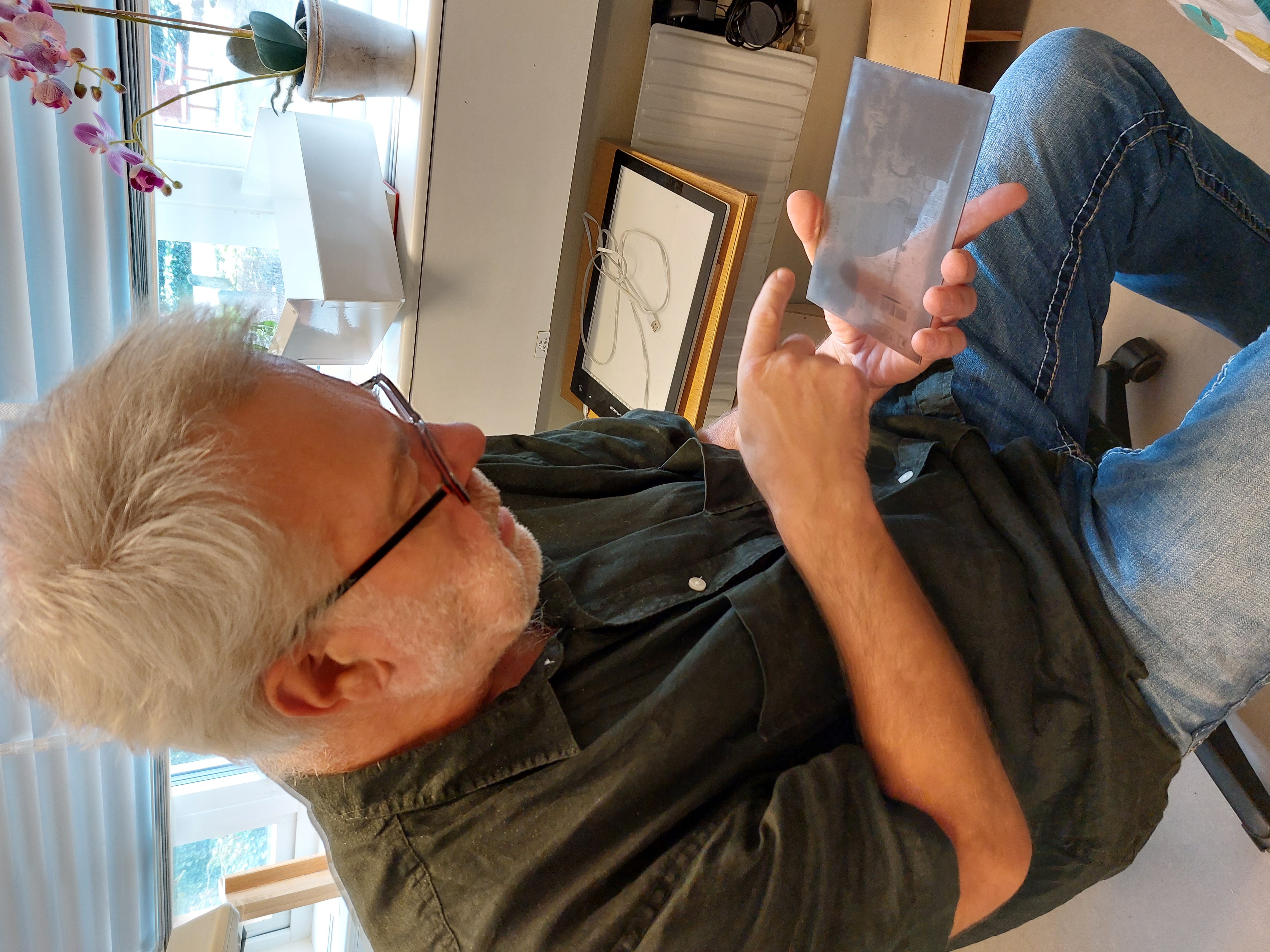 Leif Wallentinsson visar upp en glasplåt från en nyinkommen fotosamling.