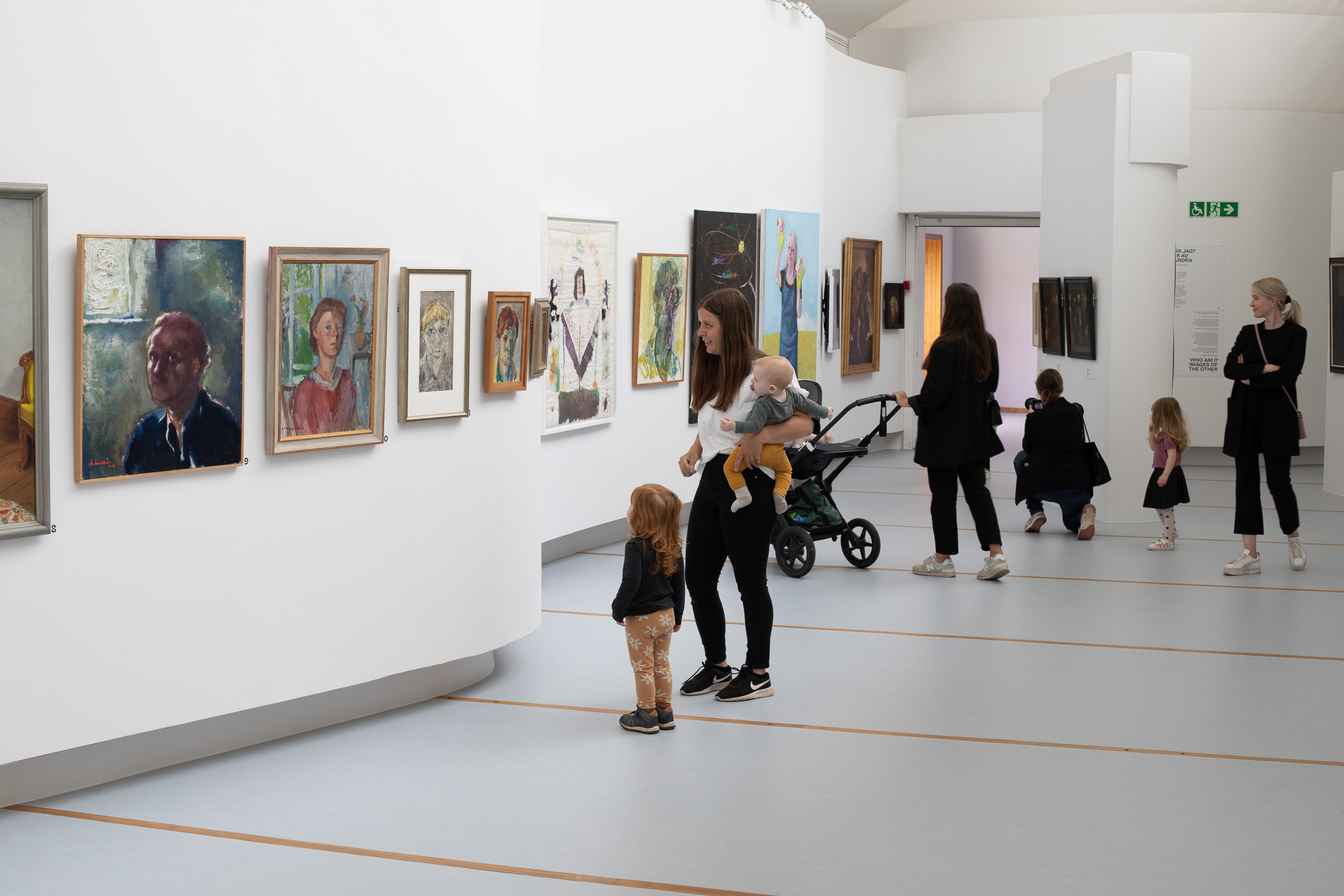 Familjer besöker Östergötlands museums konstutställning Verkligheter.