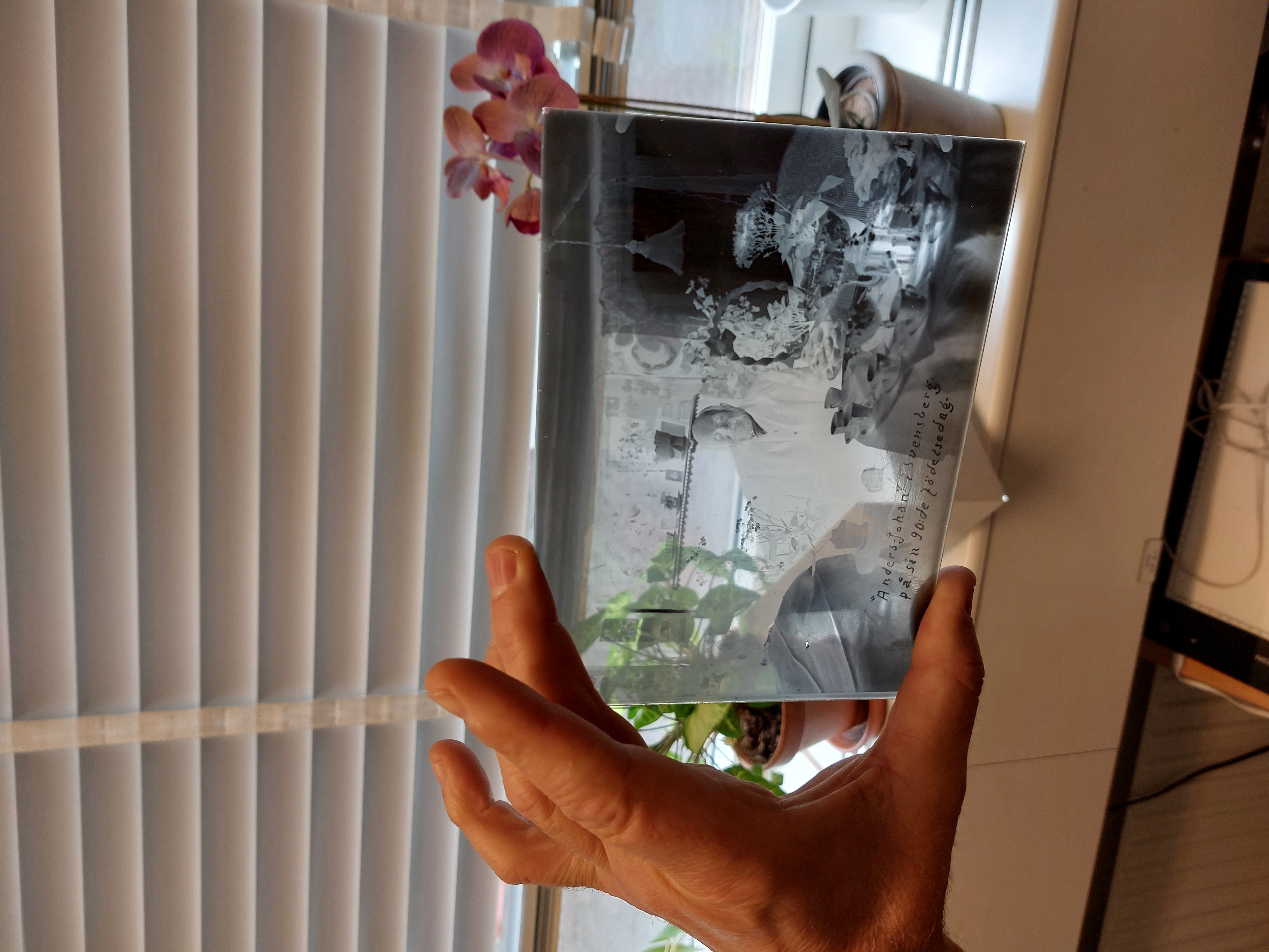 Leif Wallentinsson visar upp en glasplåt från en nyinkommen fotosamling.