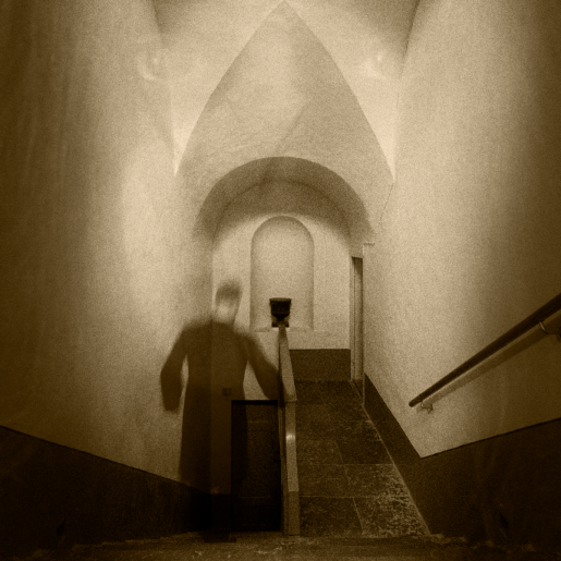 En gestalt i svart går nerför en stentrappa.