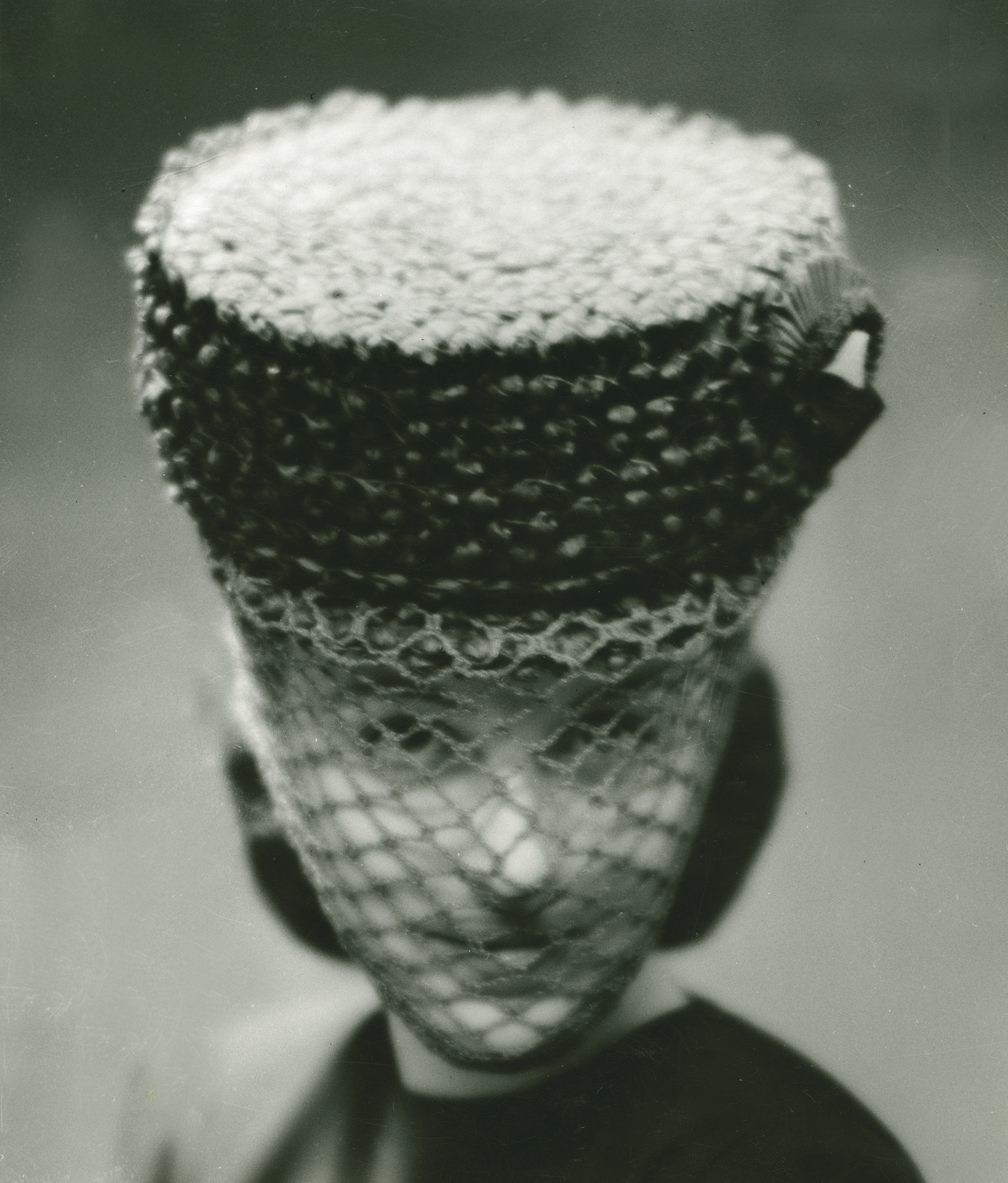 Kvinna i hatt med nät framför ansiktet 