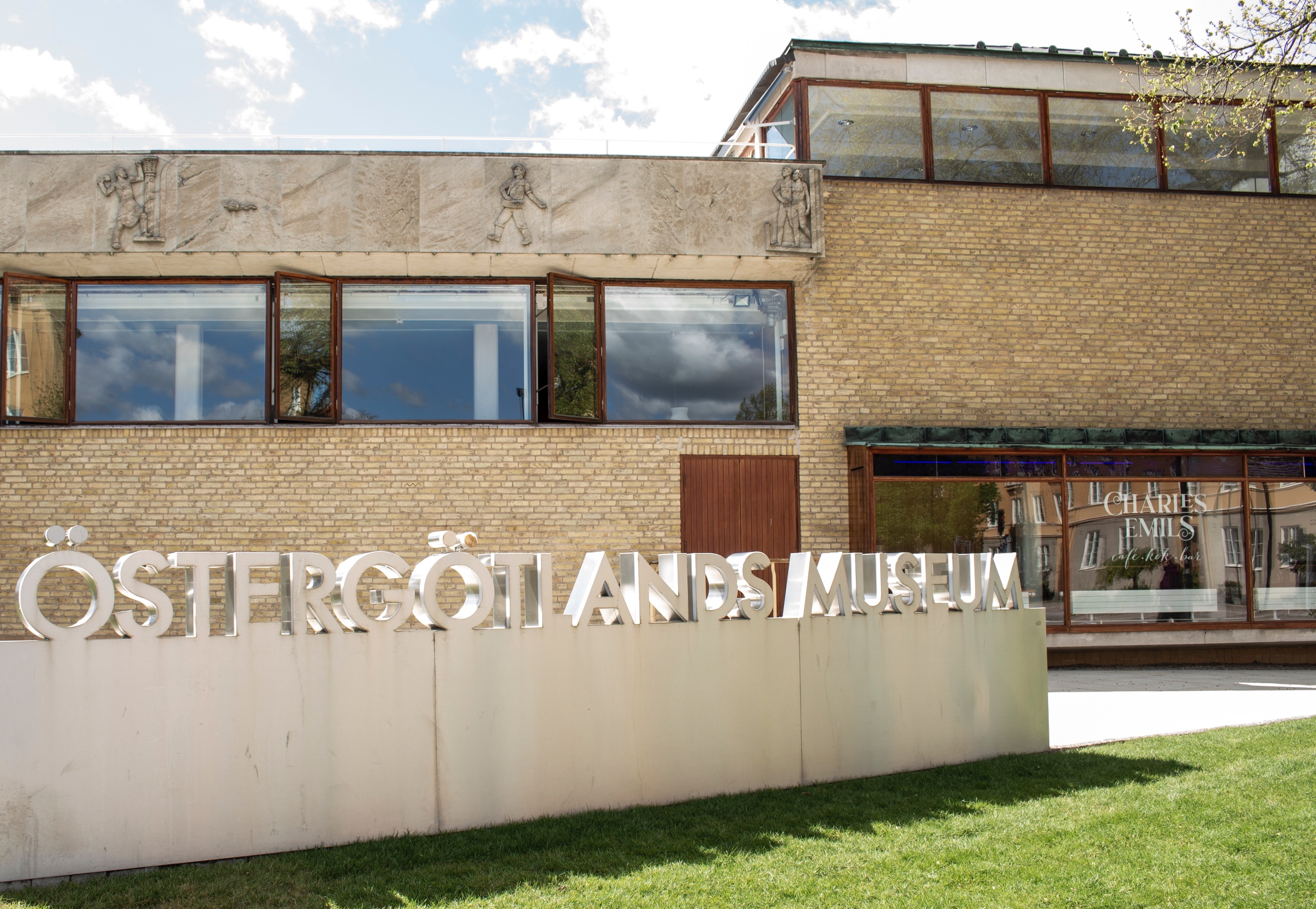 En byggnad, Östergötlands museum, med gräsmatta framför