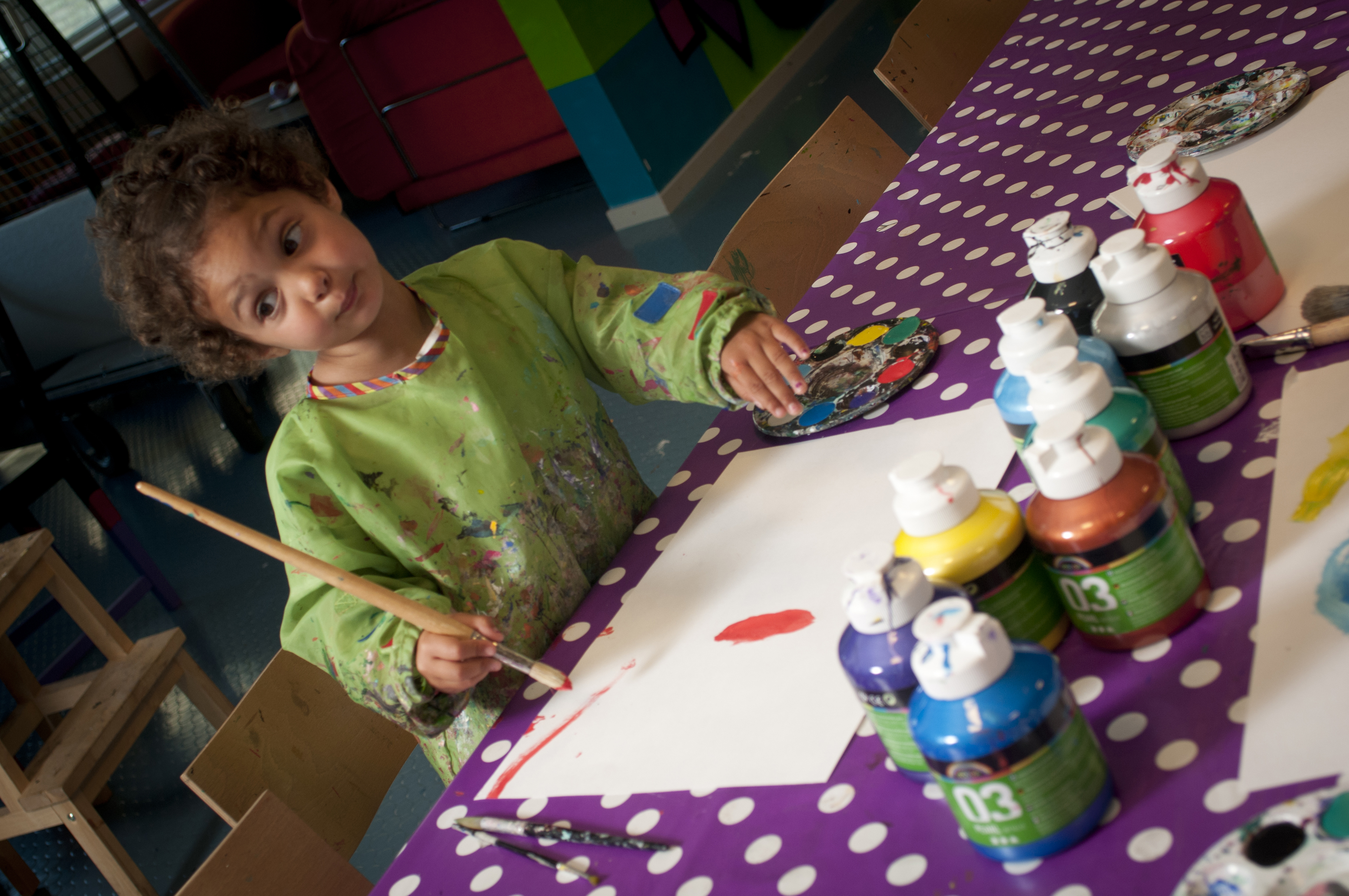 Ett barn i förkläde som färglägger 