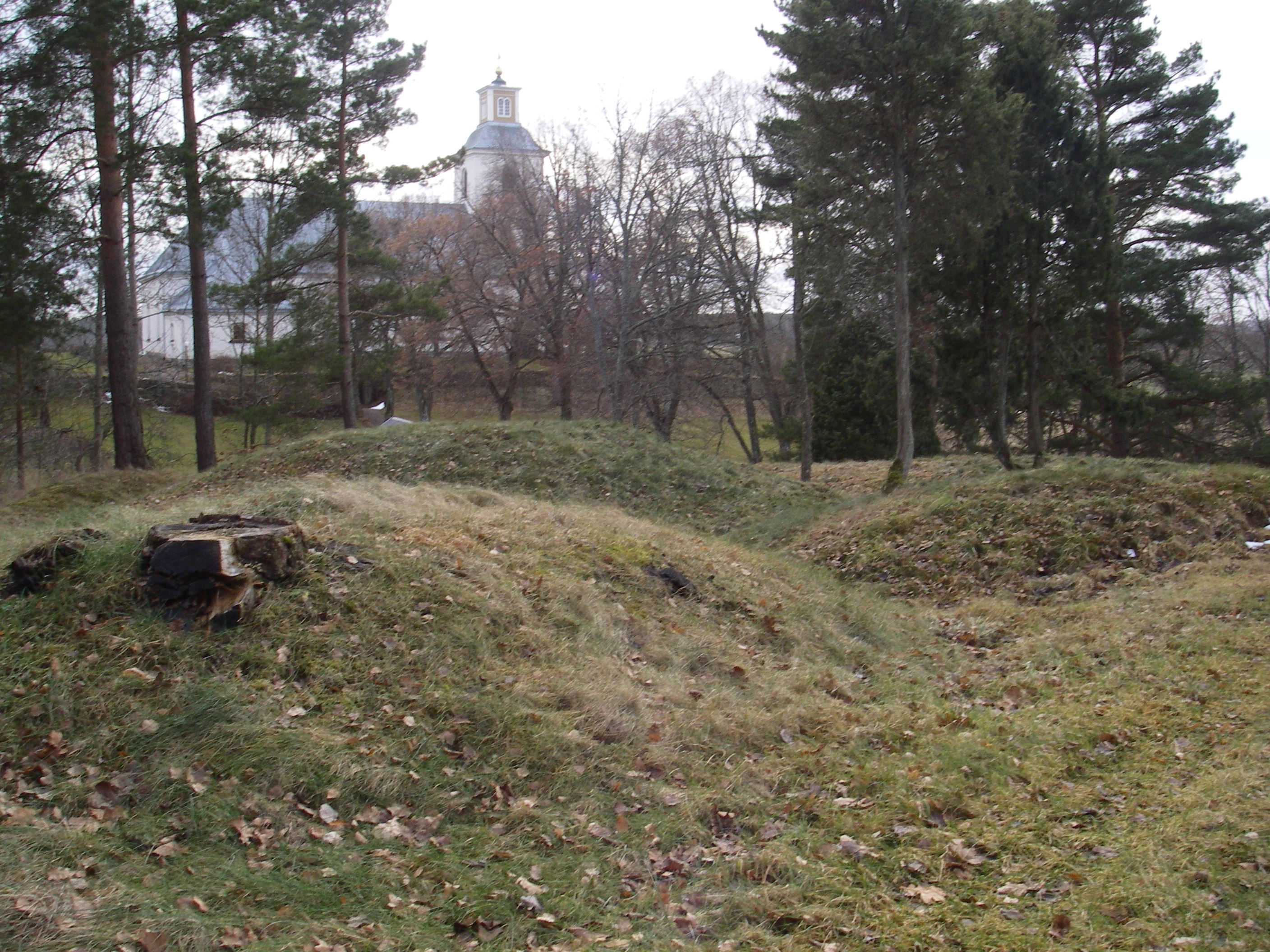 Kulterna – ett gravfält i Kättilstad, Kinda kommun. Kättilstads kyrka i bakgrunden.