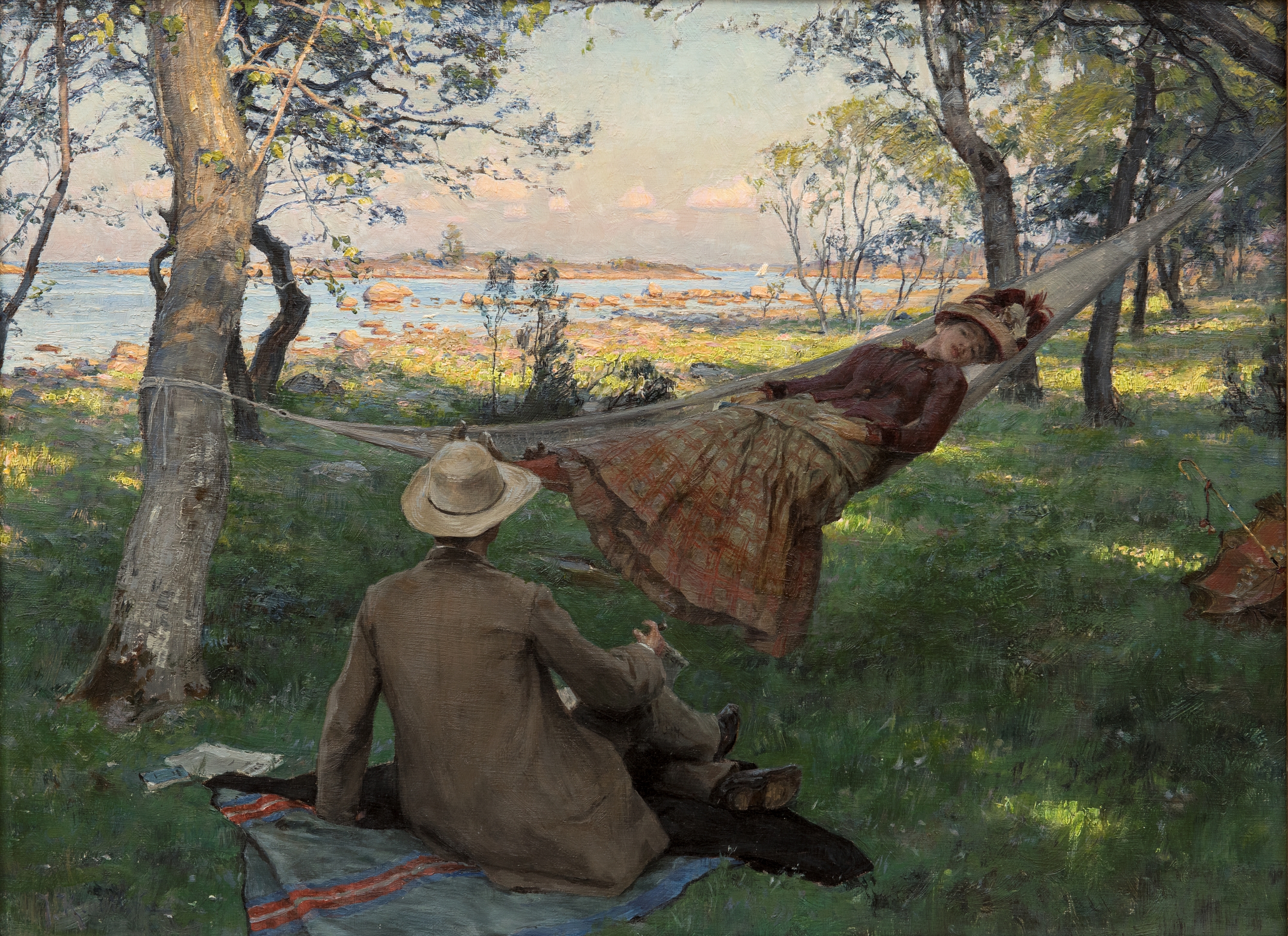 Sommarsiesta av Johan Krouthén. En man sittande på en picknickfält i gräset framför en kvinna liggande i en hängmatta.