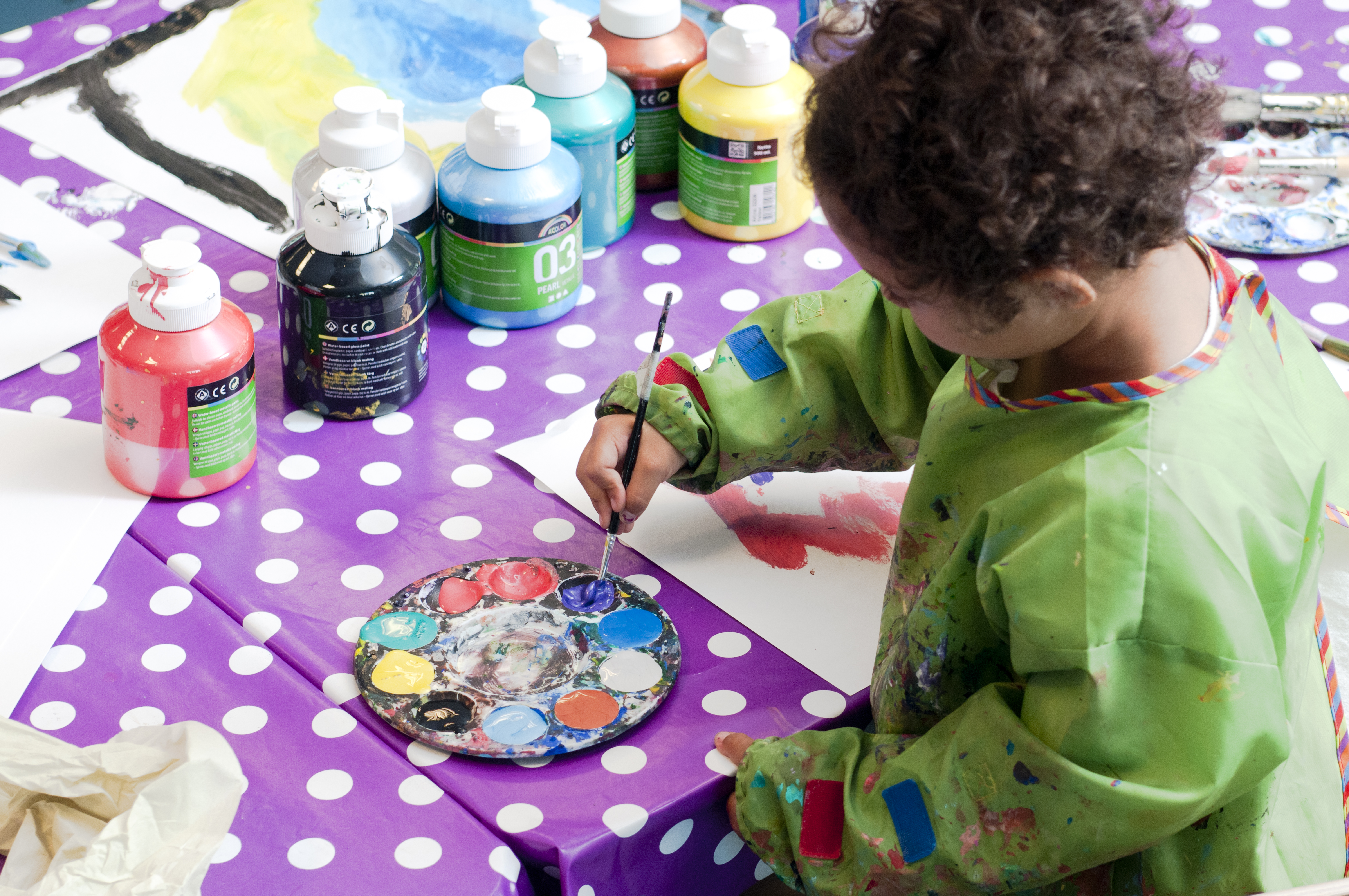 Ett barn målar i Ateljé Rut.